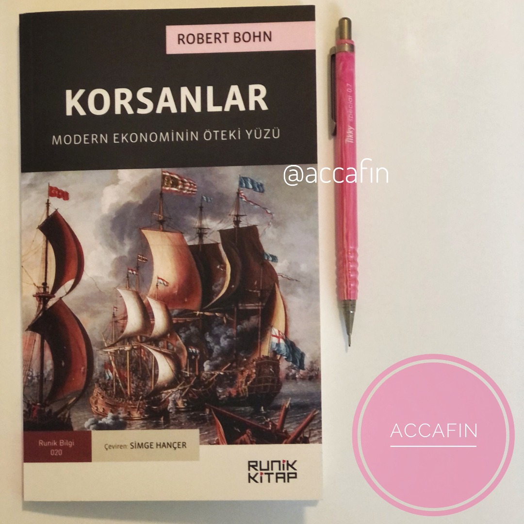 Robert Bohn'un Korsanlar: Modern Ekonominin Öteki Yüzü kitabı (Runik Kitap) masada, yanında kalem ve accafin rozeti