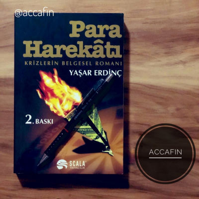 Yaşar Erdinç'in Para Harekâtı: Krizlerin Belgesel Romanı kitabı (2. baskı, Scala Yayıncılık) ahşap masada, yanında accafin rozeti