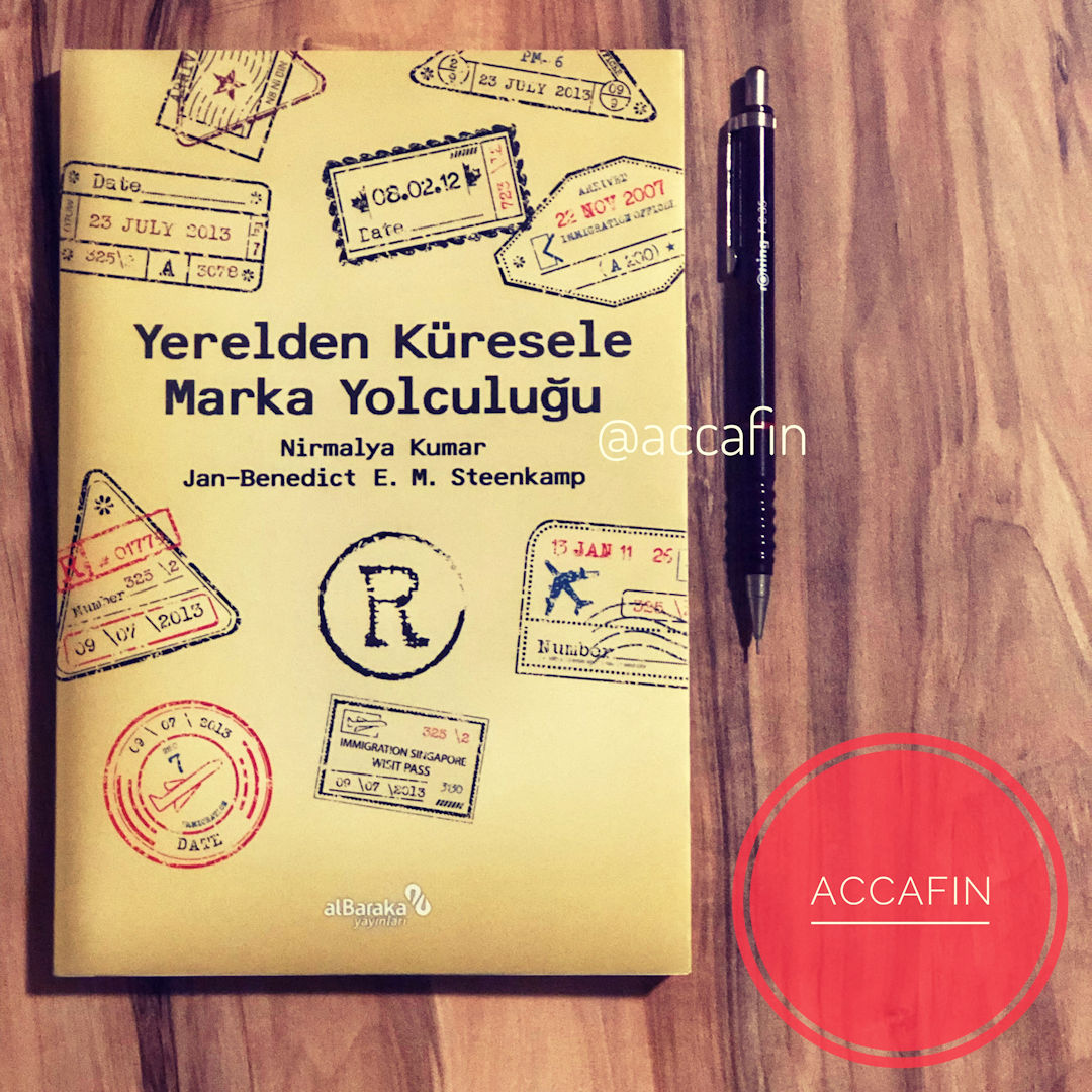 Nirmalya Kumar ve Jan-Benedict E. M. Steenkamp'ın Yerelden Küresele Marka Yolculuğu kitabı masada, yanında kalem ve accafin rozeti